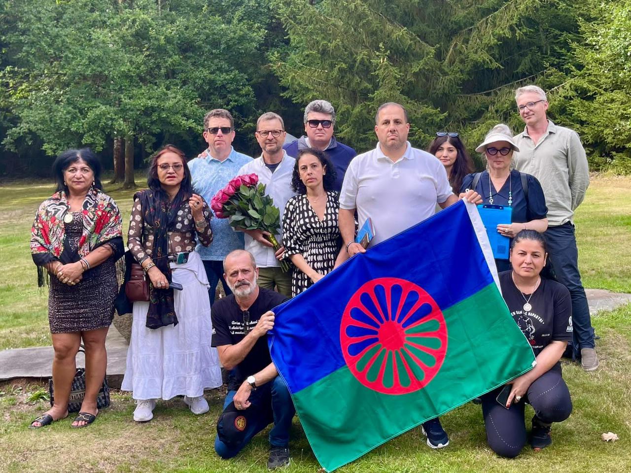 Grupo da missão internacional de memória no Lety Memorial com a bandeira Roma em primeiro plano